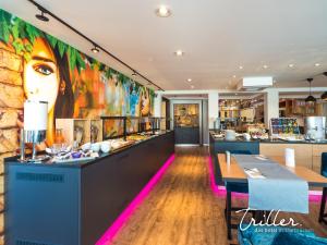 a restaurant with a mural of a woman on the wall at Hotel Am Triller - Hotel & Serviced Apartments in Saarbrücken