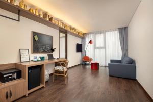 ein Wohnzimmer mit Sofa und Fernseher in der Unterkunft Mandala Hotel & Suites Bac Giang in Bắc Giang