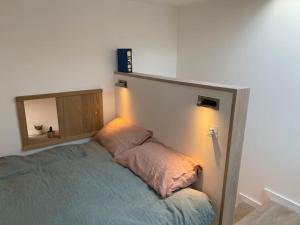 - une chambre avec un lit et un miroir mural dans l'établissement Entire Home on Victoria Park, à Londres