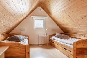 two beds in a attic bedroom with wooden ceilings at Skrea Camping in Falkenberg