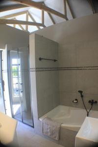 La salle de bains est pourvue d'une baignoire et d'une douche. dans l'établissement Pecan Tree Cottage, à Montagu