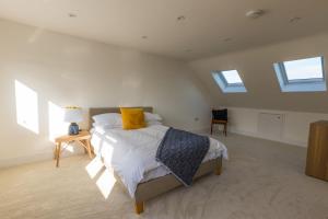 a bedroom with a bed and two windows at Amazing new 3 double bed house in staple hill! in Bristol