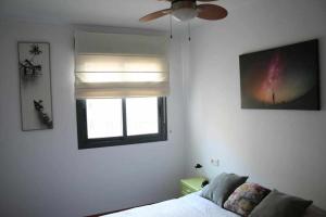 カステリョン・デ・ラ・プラナにあるLas Minvas Castellonのベッドルーム1室(ベッド1台、窓、天井ファン付)が備わります。