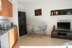 カステリョン・デ・ラ・プラナにあるLas Minvas Castellonのキッチン(テーブル、椅子、テレビ付)