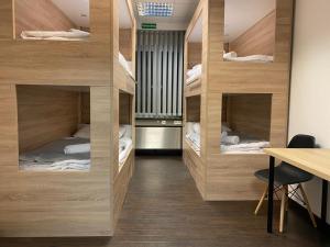 a room with four bunk beds with a table and a desk at Hostel Messe Laatzen in Hannover