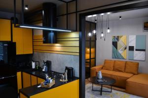 a kitchen and living room with a couch and a table at Kostjukowski brand-new apart-hotel in Lviv