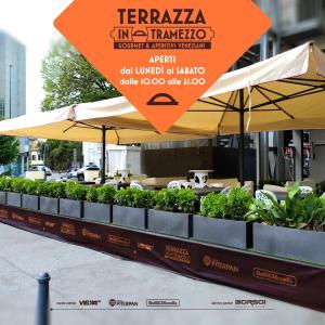 a table with umbrellas and plants on a street at Venice Terminal Apartments & Suites in Mestre