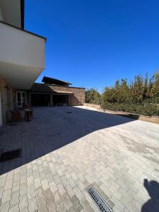 un patio vuoto con un edificio e un cielo azzurro di Casa Cost a Vetralla