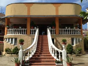 a building with a staircase leading to a house at Esenya Guest House in Adler
