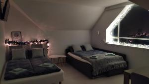 1 dormitorio con 2 camas y ventana con luces de Navidad en Guesthouse Hateigi 2, en Hella
