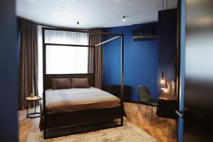 um quarto com uma cama e uma parede azul em Kostjukowski brand-new apart-hotel em Lviv