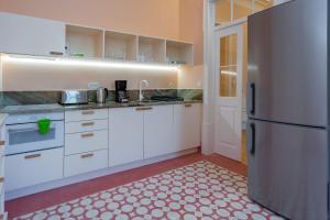 een keuken met witte kasten en een roestvrijstalen koelkast bij Pombaline Building W/Pool by LovelyStay in Vila Real de Santo António