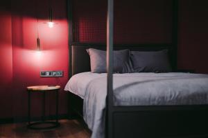 a bedroom with a bed and a red wall at Kostjukowski brand-new apart-hotel in Lviv