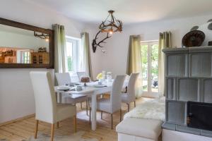 a dining room with a white table and chairs at Forest Chalet, secluded location, 1,000 sqm garden, mountainview, panorama sauna, whirlpool, BBQ&bikes&sunbeds for free, up to 10 p in Golling an der Salzach