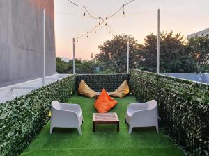 a small patio with two chairs and a table and chairs at Tuju Arteri Pods in Jakarta