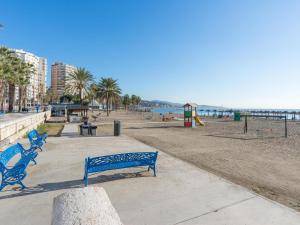 dos bancos azules sentados en una acera cerca de la playa en LU&CIA Malagueta 9, en Málaga