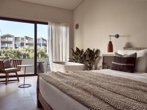 a white bedroom with a large bed and a balcony at Contessina Hotel in Tsilivi