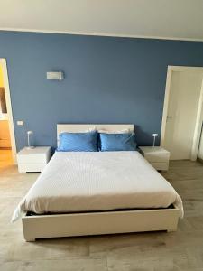 1 dormitorio con 1 cama grande y pared azul en Casa Cost 2, en Vetralla