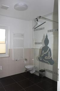 a bathroom with a toilet and a sign on the wall at Ostsee-Luxus-Ferienwohnung Sanitz in Sanitz