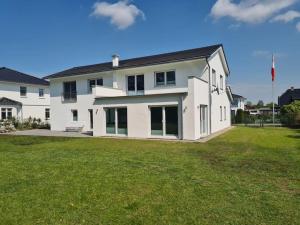 a large white house with a large yard at Ostsee-Luxus-Ferienwohnung Sanitz in Sanitz