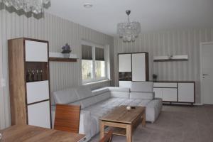a living room with a white couch and a table at Ostsee-Luxus-Ferienwohnung Sanitz in Sanitz