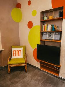 een woonkamer met een flatscreen-tv en een stoel bij Quattrozerotre in Turijn