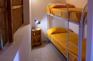 a bunk bed room with two bunk beds and a lamp at Lido Paradiso Resort in Pisciotta
