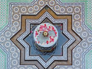 einen Kuchen mit Blumen auf dem Tisch in der Unterkunft Riad Sultan Suleiman in Marrakesch