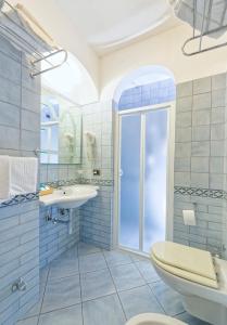Baño azul con aseo y lavamanos en Hotel Punta Imperatore, en Isquia