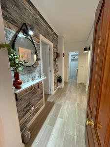 a hallway with a mirror on a brick wall at Apartamento Entrebateas in Aldán