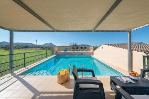 een zwembad met stoelen en een tafel met uitzicht bij Sunset Finca Can Gosp in Alcudia