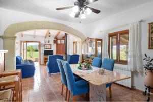 een eetkamer met een tafel en blauwe stoelen bij Sunset Finca Can Gosp in Alcudia
