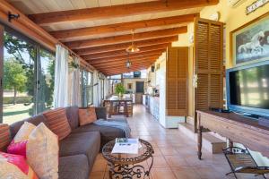 een woonkamer met een bank en een tv bij Sunset Finca Can Gosp in Alcudia