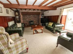 a living room with leather furniture and a fireplace at The Granary in Morpeth