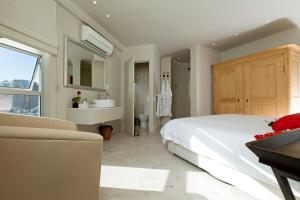 a bedroom with a large white bed and a sink at Rouge on Rose Boutique Hotel in Cape Town