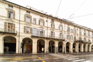 a large white building with arches on a street at Castello Central & Panoramic Studio in Turin