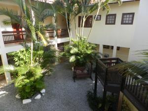 a courtyard with trees and plants in a building at Pousada do Bosque in Rio das Ostras