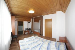 Un dormitorio con una cama y un techo de madera. en Pensiunea Pui de Urs Sirnea, en Fundata