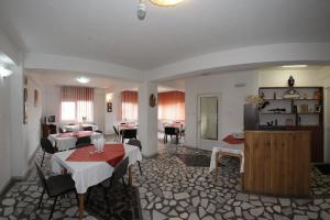 Una sala de estar con mesas y sillas en una habitación. en Pensiunea Pui de Urs Sirnea, en Fundata