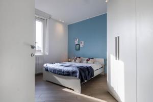 a bedroom with a bed with a blue wall at JOIVY Mazzini Brera in Milan