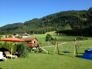 einen Spielplatz auf einem Feld mit einem Hügel im Hintergrund in der Unterkunft Mesnerhof in Brandenberg