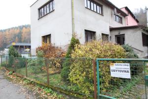 ein Zaun vor einem Haus mit einem Schild darauf in der Unterkunft Galerka Líšný in Líšný