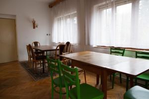 a dining room with tables and green chairs at Galerka Líšný in Líšný