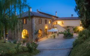 a large stone house with a courtyard at dusk at Agriturismo Renello in Petroio