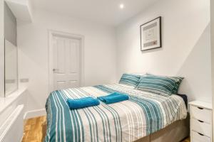 una camera da letto con un letto con cuscini blu di Holland Park Apartment a Londra