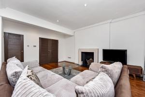 a living room with a couch and a tv at Marylebone Apartment in London