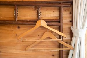 a bunch of wooden hangers hanging from a wall at Soil in Minami Aso