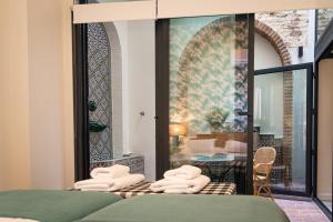 Una habitación con una cama con toallas blancas. en La Casa del Pintor Apartments, en Sevilla
