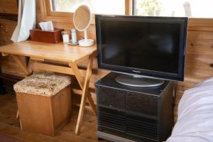 une télévision assise sur une table dans une chambre dans l'établissement Soil, à Minami Aso