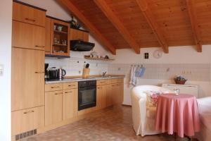 eine Küche mit Holzschränken und einem Tisch im Zimmer in der Unterkunft Ferienwohnung Gruber in Teisendorf